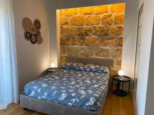 a bedroom with a bed and a brick wall at Cavour 106 Apartment in Palermo