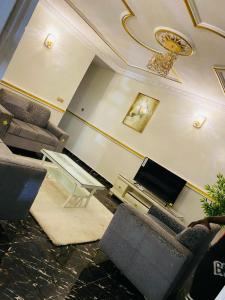 a living room with couches and a flat screen tv at Golden fortune Hotel apartment in Molyko