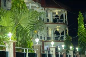 a large white building with lights in front of it at Golden fortune Hotel apartment in Molyko