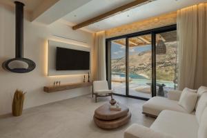 a living room with a couch and a tv at Nekyra Villa in Zóla