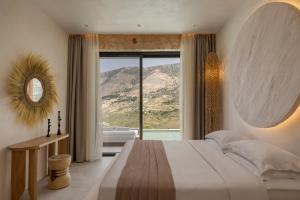 a bedroom with a large bed with a large window at Nekyra Villa in Zóla +49 photos