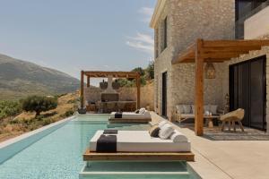 two beds in a pool next to a house at Nekyra Villa in Zóla