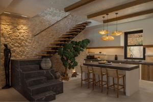 a kitchen with a staircase and a bar with stools at Nekyra Villa in Zóla
