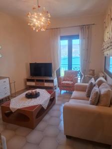 a living room with a couch and a tv at SuiteViewPoros-Luxury Apartment in Galatas in Galatas