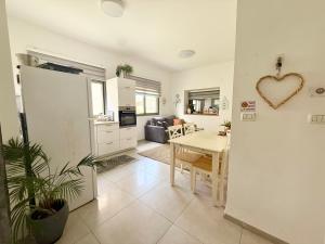 a kitchen and living room with a table and a heart on the wall at הפינה של טלי בנהריה - יחידות אירוח וספא בריאות in Nahariyya
