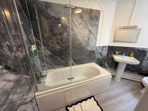 a bathroom with a bath tub and a sink at Grande Italia Rooms Comfort Italian Hospitality 4 in Ebley