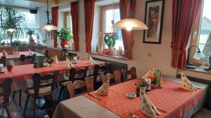 a restaurant with long tables and chairs with red table cloth at Hotel-Gasthof Lamm in Rot am See