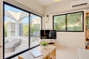 a living room with a tv and large windows at Merika Complex 1 in Perivolia