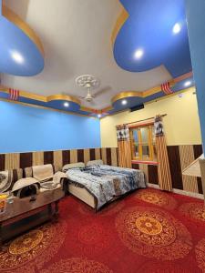 a bedroom with a bed and a blue ceiling at DANGWAL HoTEL in Srīnagar