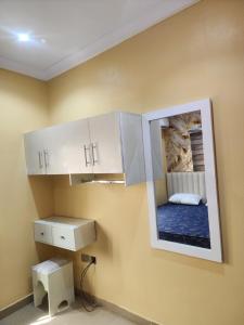 a room with white cabinets and a mirror on the wall at The Oasis in Ilorin