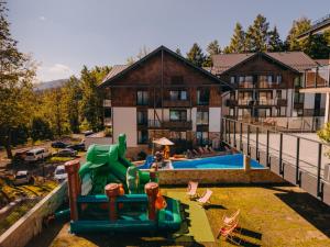 Ein Spielplatz mit Wasserrutsche vor einem Gebäude. in der Unterkunft Elements Hotel&Spa in Świeradów-Zdrój