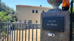 a sign on a fence in front of a gate at Appart Allée des chênes in Furiani
