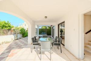 a dining room with a table and chairs on a patio at Merika Complex 1 in Perivolia