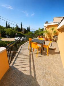 a patio with a black table and yellow chairs at Peace in Bečići