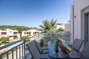 a table and chairs on a balcony with a view at A&E Cretan Oasis in Loutra
