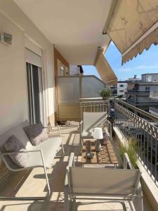 a balcony with chairs and a table on a balcony at Sea And Sand Apartment in Nea Kallikrateia