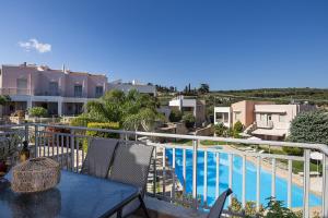 a balcony with a table and a swimming pool at A&E Cretan Oasis in Loutra