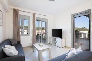 a living room with a couch and a tv at A&E Cretan Oasis in Loutra