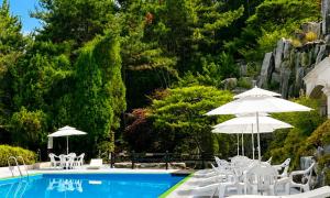 a swimming pool with white chairs and umbrellas next to it at Seosansoo Golf & Resort in Seosan