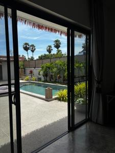a sliding glass door looking out onto a swimming pool at Villa jay in Na Mueang
