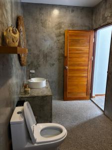 a bathroom with a toilet and a sink at Villa jay in Na Mueang