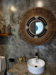 a bathroom with a sink and a mirror at Villa jay in Na Mueang