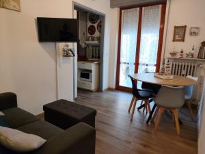 a living room with a table and a kitchen at Casa Patrik in Pietra Ligure