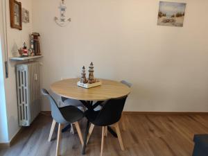 a dining room table with four chairs and a table at Casa Patrik in Pietra Ligure