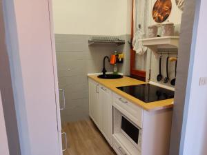 a small kitchen with a sink and a stove at Casa Patrik in Pietra Ligure +4 photos