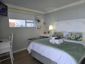 a bedroom with a bed with towels on it at View on 42 - Protea Room - Small cozy room with ocean view in Mossel Bay
