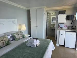 a bedroom with a bed with towels on it at View on 42 - Protea Room - Small cozy room with ocean view in Mossel Bay