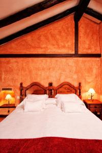 ロス・レアレホスにあるRural Las Llanadasのベッドルーム1室(大型ベッド1台、白いシーツ、枕付)