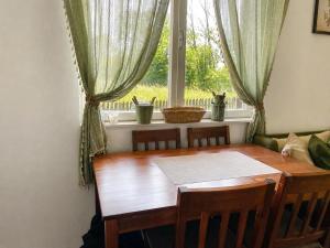 a dining room table and chairs in front of a window at Takovo Hills in Vrnčani +22 photos