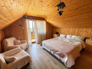 a bedroom with a bed and a chair in a room at Takovo Hills in Vrnčani