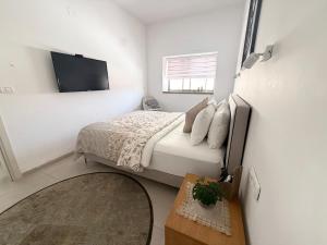 a bedroom with a bed and a tv on a wall at הפינה של טלי בנהריה - יחידות אירוח וספא בריאות in Nahariyya +33 photos