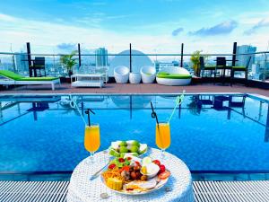 a plate of food on a table next to a pool at Roliva Hotel & Apartment Danang in Danang