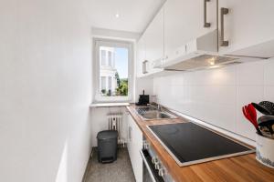 a white kitchen with a sink and a window at Charmante Stadtwohnung im Zentrum in Wiesbaden