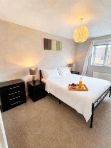 a bedroom with a bed with a tray of fruit on it at 2BR House By Cozy Quarters Property Management Contractors Accommodation Spennymoor With Parking in Spennymoor