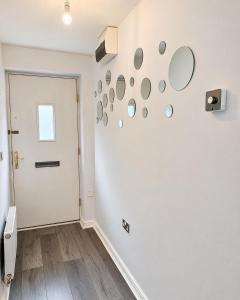 a room with a white wall with mirrors on it at 2BR House By Cozy Quarters Property Management Contractors Accommodation Spennymoor With Parking in Spennymoor +7 photos