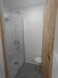 a shower with a glass door and a stool in a bathroom at Colònies Cadí - Cal Caló in Bellver de Cerdanya +21 photos
