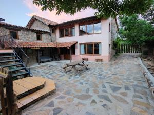 a house with a stone patio in front of it at Colònies Cadí - Cal Caló in Bellver de Cerdanya