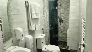 a bathroom with a toilet and a sink and a shower at Hotel Rile Men Blue in Niš