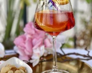 a glass of wine and a bowl of nuts on a table at Villa Pruly Hotel Cannes Centre in Cannes