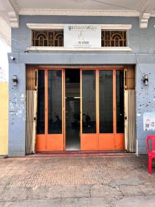 an entrance to a building with orange doors and a red bench at Home Frog Guesthouse in Phnom Penh