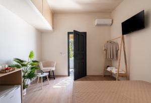 a bedroom with a bed and a tv in a room at Ornos Collection - by Hospirit in Ornos