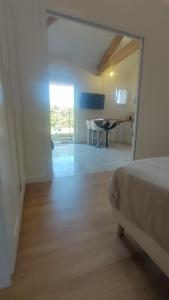 a bedroom with a bed and a table in a room at Pause au coeur des Côtes-Rôtie in Ampuis