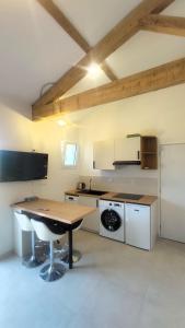 a kitchen with a wooden table and a counter top at Pause au coeur des Côtes-Rôtie in Ampuis