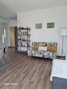 a living room with a couch and wooden floors at Garden House in Dég