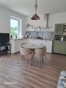 a kitchen with a table and chairs in a room at Garden House in Dég