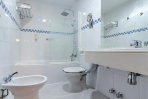 a white bathroom with a toilet and a sink at Sercotel Las Estrellas in Ciempozuelos +25 photos